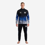 Custom soccer tracksuits for teams in black and Royal Blue galaxy gradient, full-zip stand-collar jacket and tapered pants, front view on male model