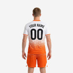 Close detail of custom soccer uniform kit showing the dense dot-burst print gradient dissolving from white chest into solid orange lower body