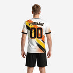 Back view of custom white and orange sublimated soccer uniform kit with back number and surname print zones visible on polyester jersey