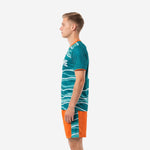 Custom soccer uniform kits teal wave sublimated jersey and orange shorts, right side view showing back name print