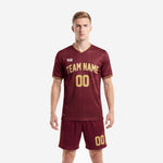Custom soccer uniform men in maroon and Athletic Gold showing front team name and number on V-neck jersey and matching shorts