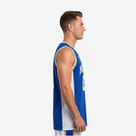 Side view of royal blue custom sublimated basketball jersey showing wide white mesh side panel and gold-trimmed armhole binding