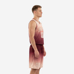 Front view of custom sublimated basketball uniforms with arched team name and number on maroon blush fade jersey and matching shorts