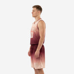 Left side view of maroon to blush fade custom sublimated basketball uniform set showing armhole binding and shorts waistband detail
