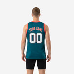 Side view of custom teal basketball jersey showing athletic cut, straight hem, and coral-red armhole binding on a male model