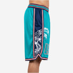 Side view of custom teal basketball shorts showing navy side panel, white wave crest graphic, pink trim stripe, and V-notch hem split