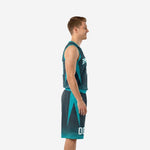 Adult male model wearing custom charcoal and teal basketball uniform set with arched team name and front number on the V-neck jersey