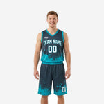 Custom teal basketball uniforms in charcoal with ink-splash sublimation, front view of full jersey and shorts set on male model