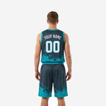 Opposite side view of charcoal and teal basketball uniform set displaying ink-splash graphic wrapping around jersey and shorts