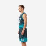 Side view of sublimated teal basketball jersey and shorts showing V-neck binding and splash pattern along the shorts leg