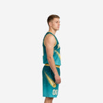 Teal basketball uniform front view showing gold V-neck binding, star-dot galaxy pattern, constellation lines, and gold glowing comet graphic on the jersey