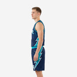 Side view of custom teal basketball uniforms showing the teal lightning-bolt panel running from the lower jersey hem down the leg of the matching navy shorts