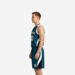 Side view of custom teal basketball jersey and shorts showing curved white and black side panel sweeping from armhole to shorts hem