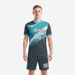 Custom teal soccer uniforms front view showing charcoal and teal gradient jersey with matching shorts on adult male model