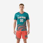 Custom teal soccer uniform with coral wave graphic and matching coral shorts, front view on adult male model