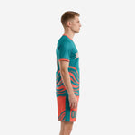 Teal soccer uniform side view showing coral wave sublimation print across jersey and coral shorts with teal stripe