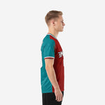 Side view of custom teal and dark red split soccer jersey showing contrast sleeve cuff trim and athletic cut fit