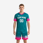 Custom teal soccer uniforms with hot pink gradient fade, front view showing team name and number on V-neck jersey and matching shorts