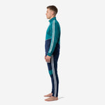 Custom teal soccer tracksuit side angle showing chevron colorblock seam between teal upper and navy lower on adult male model