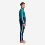 Custom teal soccer tracksuit side view displaying full-length white sleeve stripe and tapered navy pants on adult male model