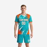 Custom teal soccer uniforms front view showing orange contrast panels and lightning bolt sublimation print on jersey and shorts set