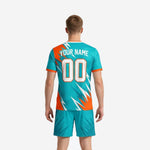 Teal and orange soccer jersey detail showing lightning bolt graphic elements and moisture-wicking polyester fabric construction