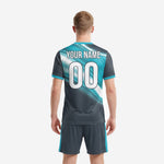 Teal and charcoal sublimated soccer jersey detail showing diagonal gradient sweep and crew neck teal trim