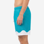Custom teal soccer shorts with full-dye sublimated teal body and white contrast hem panel, right side view on male model