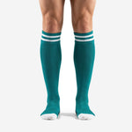 Custom teal soccer socks with double white stripe ribbed cuff, front view on male model