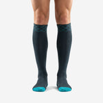 Custom teal soccer socks mens front view showing charcoal body and teal toe box with diamond cuff pattern