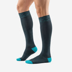 Custom teal soccer socks over the calf angled view showing teal heel cup and charcoal calf panel on adult male model