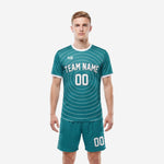 Custom teal and white soccer uniforms front view showing concentric arc pattern jersey and matching teal shorts on male model