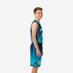 Front view of custom teal youth basketball uniform set with V-neck collar, arched team name across chest, and number 00 on a navy-to-teal gradient jersey