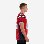 Side view of red and navy custom team football jersey showing navy side panel running from armhole to hem on adult male model