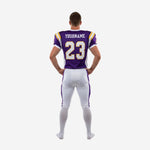Custom team football uniform right side view in purple and white, displaying jersey hem, belt area lace-front closure, and knee area of white pants