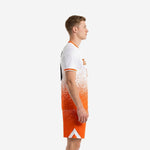 Side view of custom unique soccer uniforms showing the white-to-orange dot-burst gradient transition on the jersey and matching sublimated shorts
