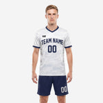 Custom white soccer uniforms with navy blue shorts, white camo sublimated jersey and player number, front view on male model