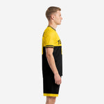 Custom yellow soccer uniform left side view displaying horizontal colorblock design and yellow hem band on black shorts