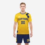 Custom yellow soccer uniform with navy blue hex panel jersey and matching navy shorts, front view on male model