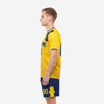 Men's custom yellow soccer uniform side view with navy shorts and athletic gold player number on left thigh