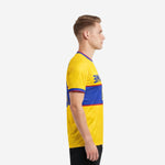 Custom yellow soccer jersey with Royal Blue horizontal band and Crimson trim, left side view on adult male model