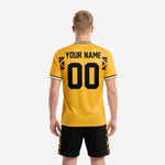 Close detail of custom yellow soccer jersey showing black geometric chest band, contrast crew neck collar banding, and sublimated team name and number
