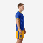 Custom yellow soccer uniform side view left showing Royal Blue jersey with Athletic Gold side panels and gold shorts with blue stripe