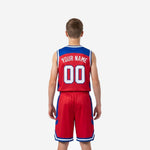 Youth player in red and royal blue custom basketball uniform set from the opposite side, showing full geometric blue panel and elastic waistband on shorts