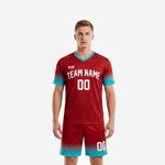 Men's custom red soccer uniform in dark red and teal gradient, front view showing team name and number on jersey and matching shorts