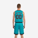 Side view of teal reversible basketball uniform showing diagonal stripe construction and contrast black trim on the shorts waistband and hem