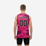 Left side view of pink and maroon digital camo basketball jerseys showing wide-cut armhole binding, V-neck collar, and hip-length straight hem