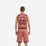 Side view of the dusty-rose reverse side of the reversible basketball uniform showing maroon contrast binding at V-neck and armholes
