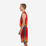 Opposite side view of red and black sublimated youth basketball jersey and shorts showing black armhole binding and continuous side stripe detail