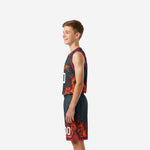 Opposite side view of youth sublimated basketball uniform in charcoal and red showing flame pattern wrapping the lower shorts panel